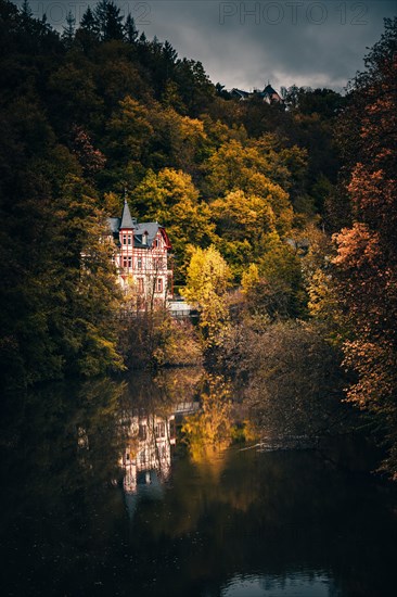 View of a half-timbered house in the forest by the river Weilburg