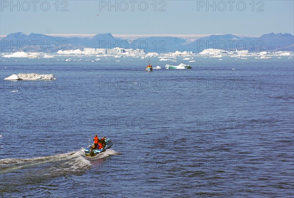 Small boat in front of iceberg near Ilulisaat harbour