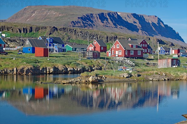 Wooden houses reflected in a calm body of water