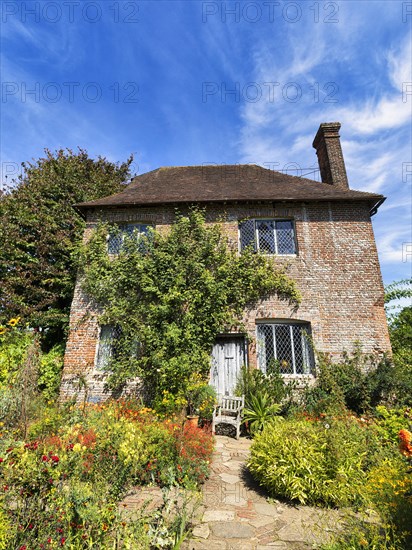 Red brick cottage with flowering front garden