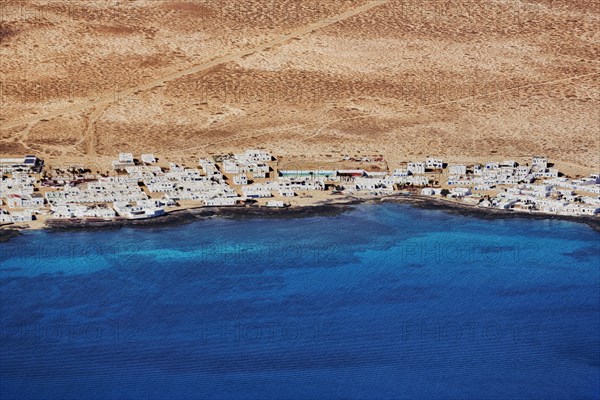 View of the white houses of Caleta del Sebo by the sea