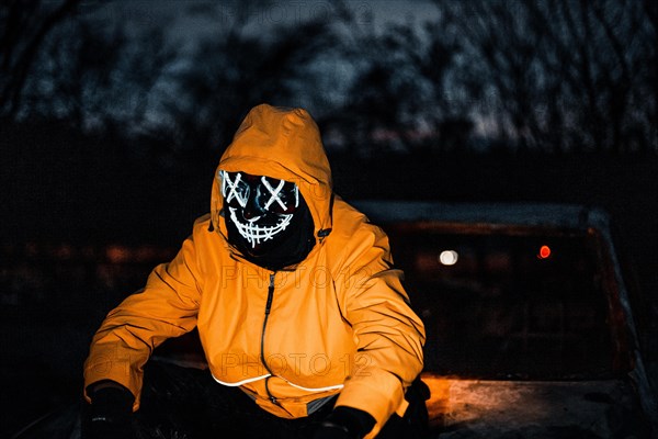 Man with Purge mask on a car wreck