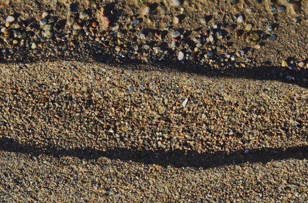 Sand formation with pebbles on the river bank after flooding