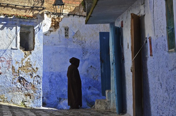 Man in jellabah standing in alley