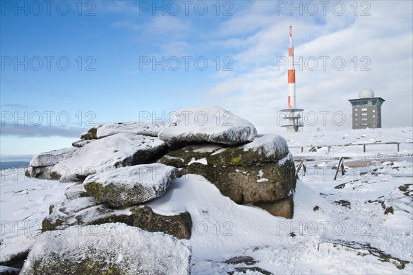 Rock with transmission mast and Brocken hostel on the wintery snow-covered Brocken