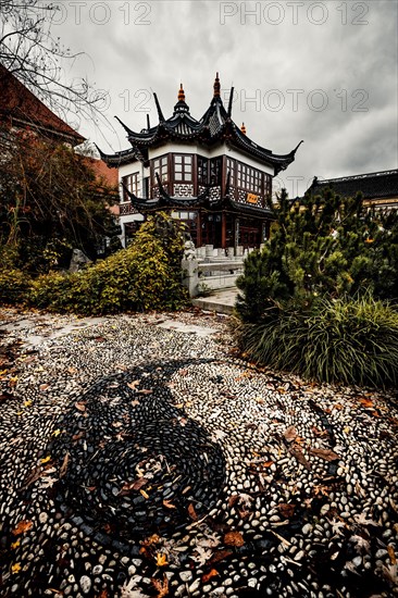 China restaurant with a great park and yin yang signs made of stones in the path