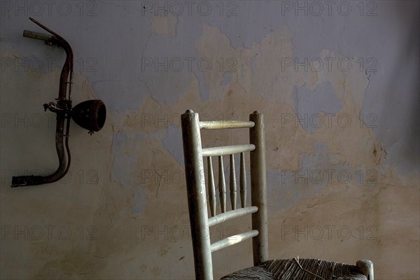 Spanish chair with handlebars from bicycle in front of wall