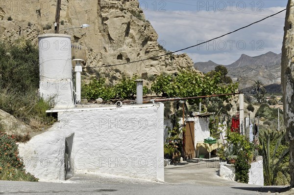 White cave house in front of rocks