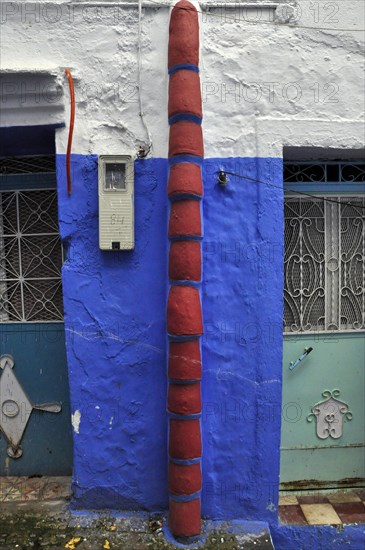 Rain gutter made of roof tiles on house wall