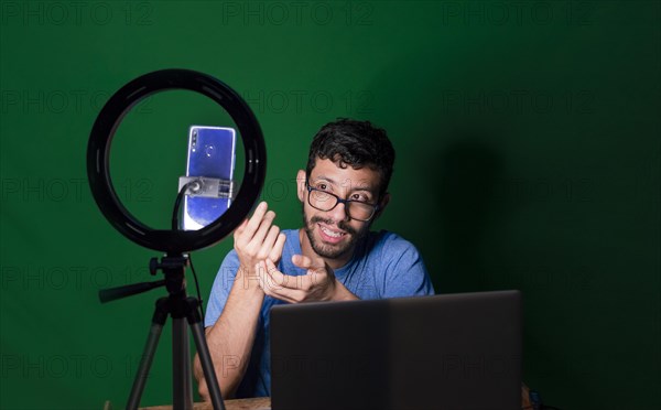 Young man with laptop making video blog