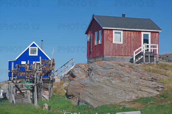 Racks of dried fish in front of simple wooden houses