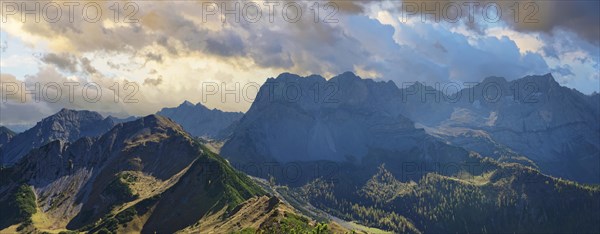 View from the summit of Gramaijoch to the Karwendel peaks of Lamsenjoch and Grubenkar under a cloudy evening sky