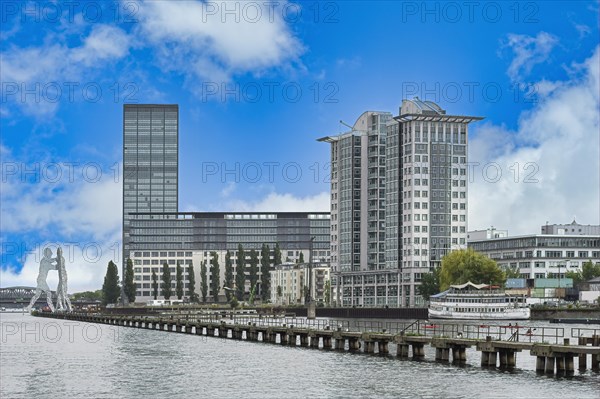 Modern buildings along the Spree river and Molecule Man behind