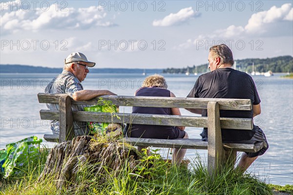 Two men and a woman on a park bench