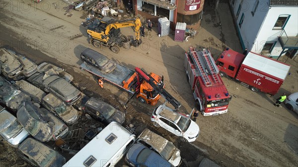 A tow truck loads wrecked cars washed away by the floods on the Ahr river in Dernau. Dernau