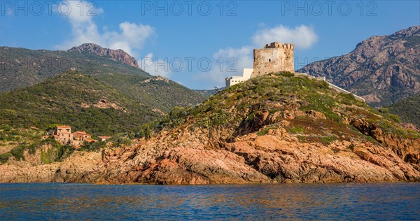 Genoese tower near the village of Girolata with staircase houses in the nature reserve of Scandola