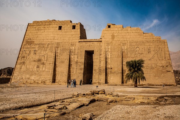 1st pylon in the funerary temple decorated with oversized relief depictions showing the pharaoh in typical displays of power slaying enemies in front of a deity