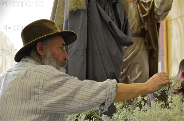 Old man with hat decorates altar in church for Easter
