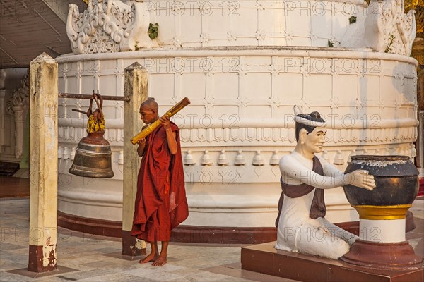 Monk ritually strikes a bell