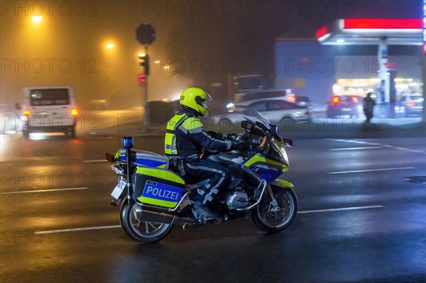 Policeman on a motorbike in front of a petrol station