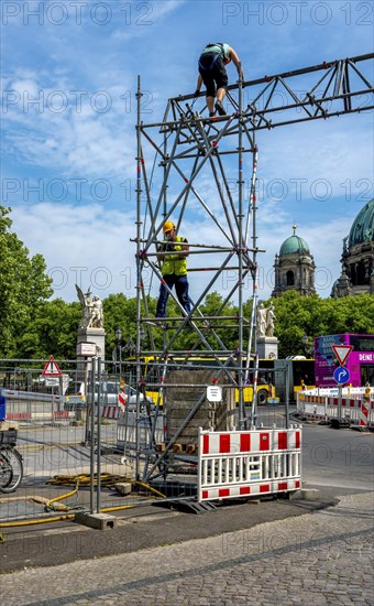 Construction workers working on scaffolding in front of the Schlossbruecke