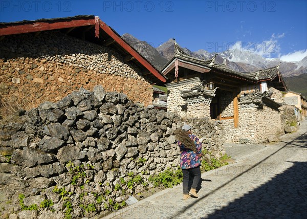 A resident carries brushwood home