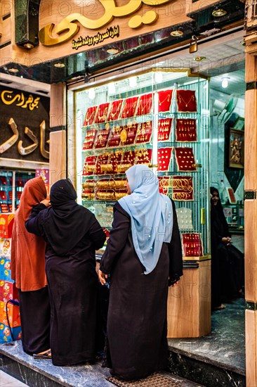 Women in front of displays of a gold jewellery shop