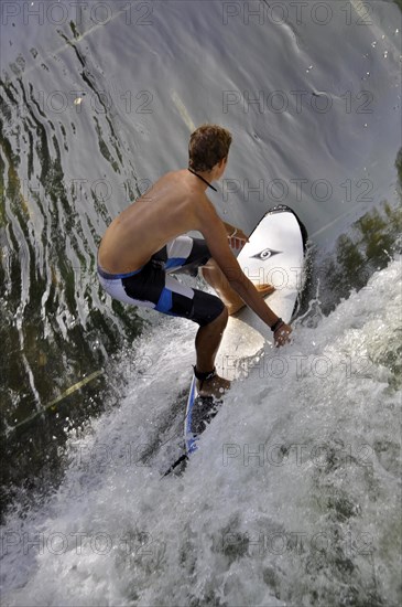 Standing surfer in the wave in the Eisbach at the Tierpark