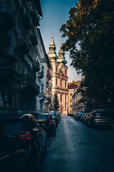 Catholic church is lit by the sun in a dark street