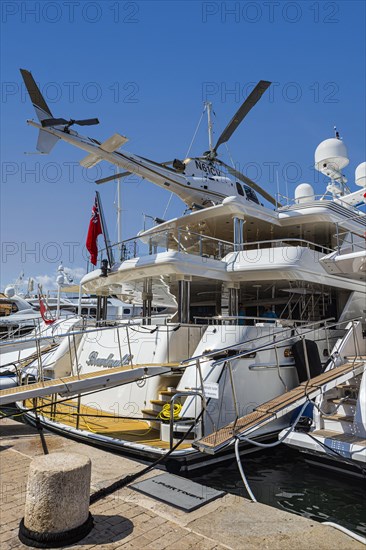Luxury yacht with helicopter on deck anchored in the harbour of Saint Tropez