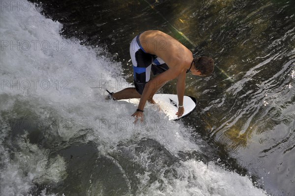 Standing surfer in the wave in the Eisbach at the Tierpark