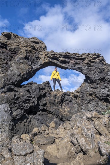 Tourist standing in a rock arch