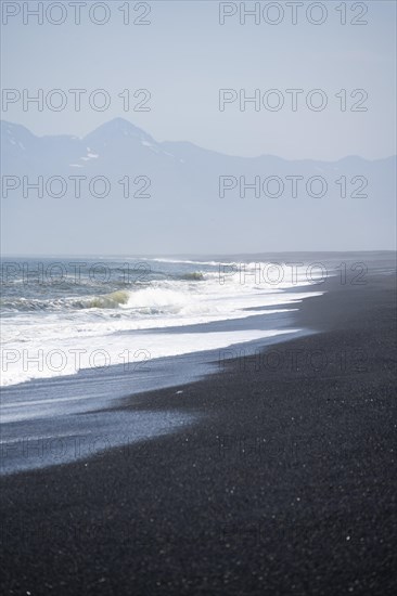 Black sandy beach by the sea