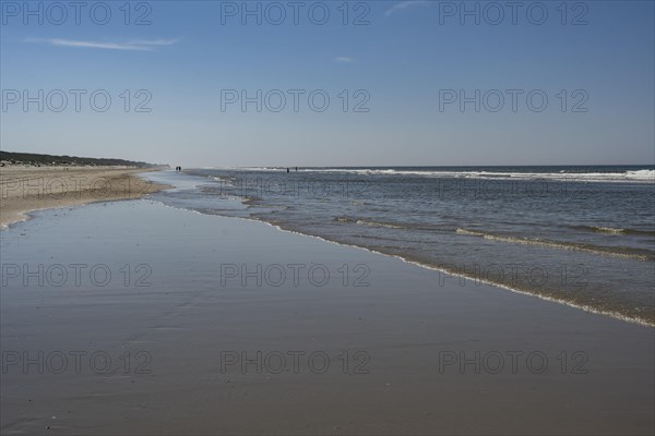 Long sandy beach with outgoing waves