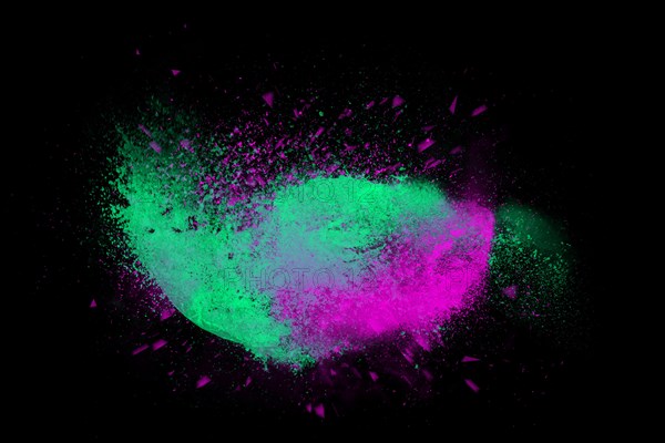 Freeze motion of colorful powder paint exploding isolated on black dark background. Abstract design of color dust cloud. Particles explosion screen saver