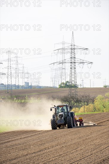 Tractor with seed drill in the field in spring