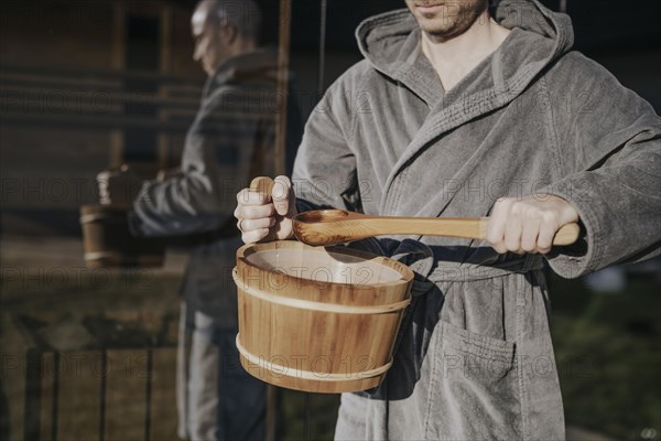 Man with infusion tub in sauna