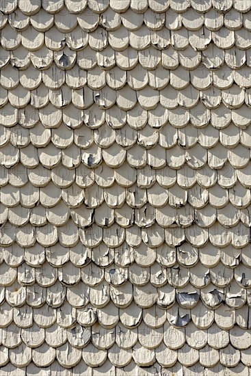 pattern of old wooden shingles with peeling paint