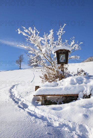 Snow-covered wayside shrine in Mondseeland