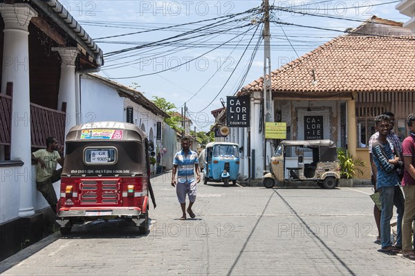 People and tuk tuks in the street