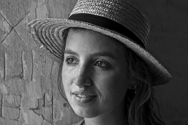 Young woman with straw hat and nose piercing sweats