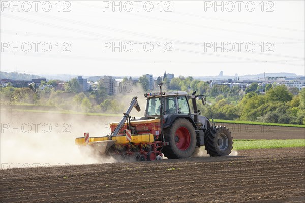 Tractor with seed drill in the field in spring