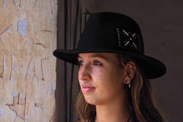 Young woman with black hat and nose piercing