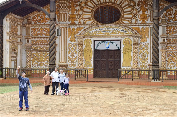 Family taking a picture in front of the painted facade of the Catedral Inmaculada