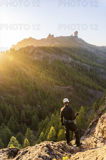 Man with professional gear doing rappelling sport in beautiful scenery of Roque Nublo mountain