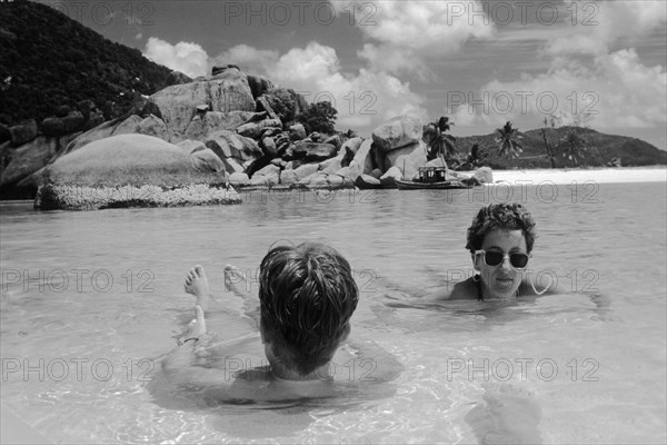 European tourists lying in shallow water by the sea