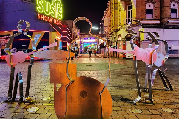 Beatles metal figures on Beatles Square at night