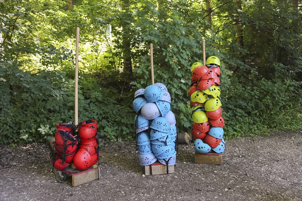 Many stacked helmets in the forest ropes course