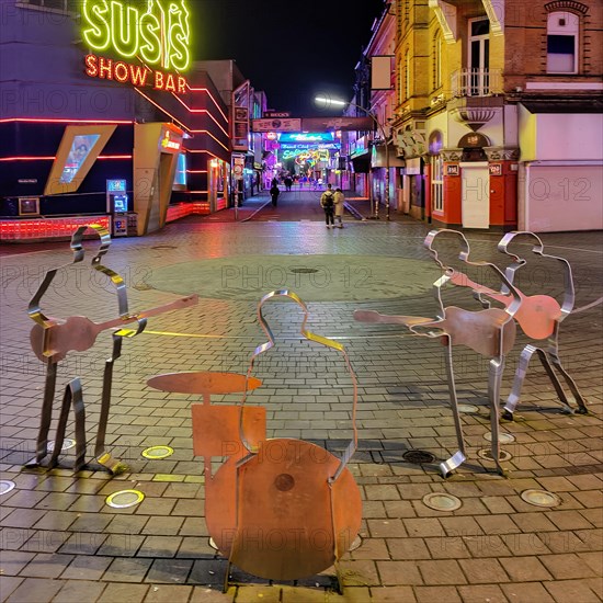 Beatles metal figures on Beatles Square at night