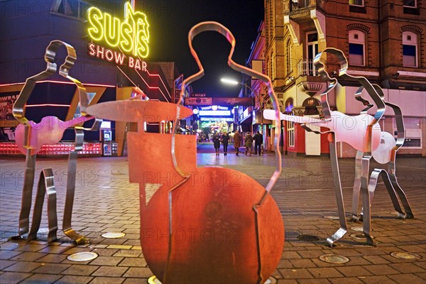 Beatles metal figures on Beatles Square at night